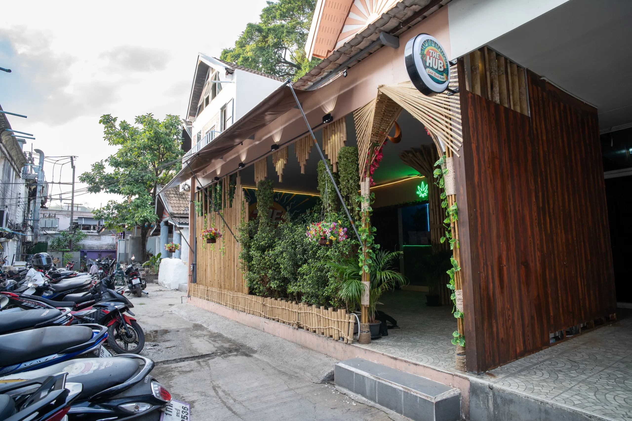 The Hub Laidback Hostel's bamboo-and-greenery frontage on a sunny day in Ao Nang, Krabi